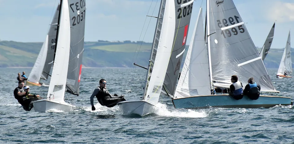Scorpion dinghies racing to the windward mark, crews hiking out